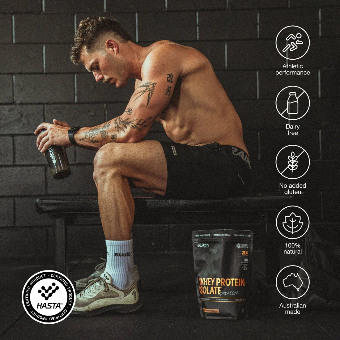 A muscular man in athletic wear sits on a gym bench, holding a shaker bottle. Switch Nutrition Perform Whey Protein Isolate - Chocolate 750g is on the floor nearby, with icons for performance, lactose-free, natural, and Australian made.
