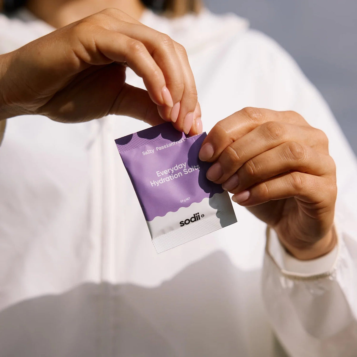 Person holding a purple sachet of Salty Passionfruit - 30 Sachets by Sodii from the Electrolytes collection